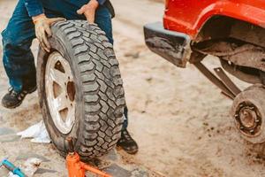 homem mudar a roda manualmente em um caminhão 4x4 off road foto