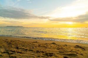 bela praia tropical e mar com céu crepuscular foto