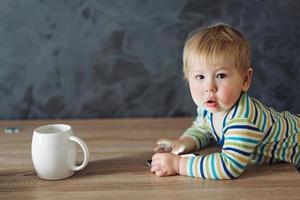 menino em pé perto da mesa foto