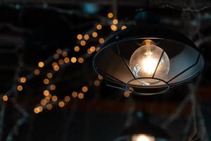 lâmpada pendurada do lado de fora em um fundo escuro. foto