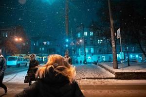 casal adulto jovem andando na calçada coberta de neve foto