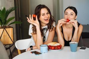 duas amigas tomando café da manhã na cozinha foto