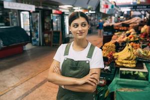 mulher vendedora de frutas no mercado perto do balcão foto