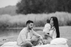 família jovem feliz relaxando juntos no lago foto