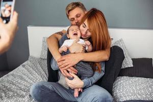 família feliz com bebê recém-nascido na cama foto