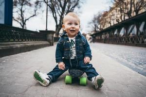 menino engraçado com skate na rua foto