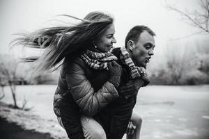 homem carrega sua namorada nas costas foto