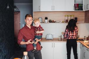 pai, mãe e filho pequeno na cozinha foto