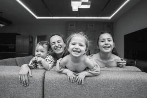 mãe, duas filhas e um filho pequeno no sofá