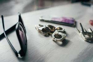 óculos de sol e anéis em uma mesa foto