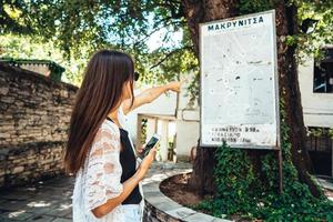 mulher aponta para o mapa de marcos da cidade. makrinitsa foto