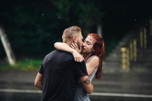 lindo casal beijando na chuva foto