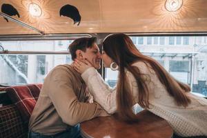 amando o jovem casal no inverno sentado em um café foto