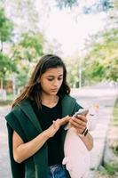 jovem atraente digitando mensagens em seu celular. foto