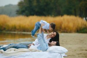 família jovem feliz relaxando juntos no lago foto