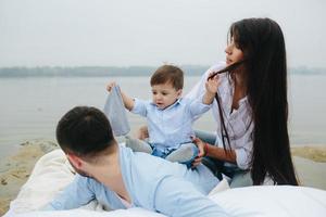 família jovem feliz relaxando juntos no lago foto