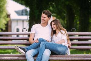 homem e mulher em um banco no parque foto