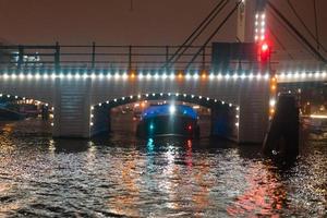 iluminação noturna de edifícios e barcos no canal. foto