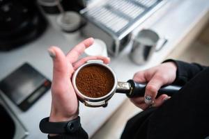 barista segurando porta-filtro com café moído foto