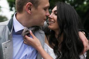 jovem casal europeu abraçando em um banco do parque foto