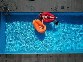 mãe e filhas estão descansando na piscina. foto