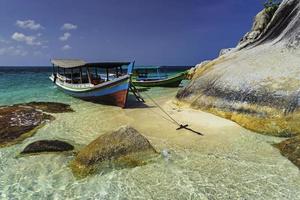 grandes pedras com um barco turístico foto