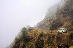 carro movendo-se para cima na estrada em zig zag da montanha da rota da seda sikkim foto