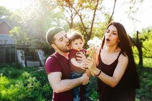 jovem família com uma criança na natureza foto