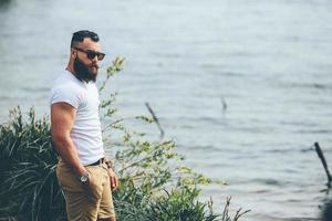 homem barbudo americano parece na margem do rio foto