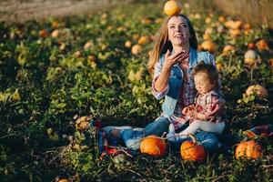 mãe e filha em um campo com abóboras foto