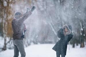 homem e mulher jogando bolas de neve foto
