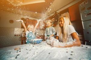 mãe com filhos na cozinha foto