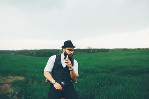 homem de barba fuma cigarro eletrônico foto