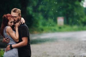 lindo casal abraçando na chuva foto