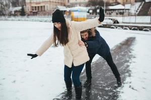 homem e mulher patinam no gelo foto