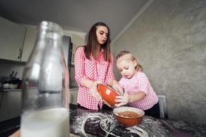 mãe e filha juntas na cozinha foto