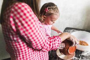 mãe e filha juntas na cozinha foto