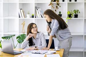 uma empresária e um colega estão usando computadores para calcular o último trimestre do orçamento de renda do ano para planejar investimentos financeiros para o próximo ano. foto