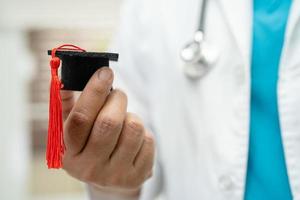 estudo de médico asiático aprende com chapéu de graduação na enfermaria do hospital, conceito de medicina de educação de gênio brilhante inteligente. foto