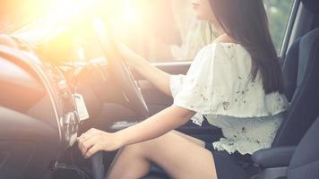 linda jovem com um belo sorriso dirigindo um carro. visão traseira. foto