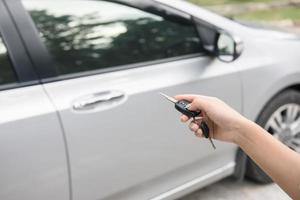 a mão das mulheres pressiona os sistemas de controle remoto do carro foto