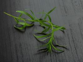 folhas de estragão em fundo de madeira foto