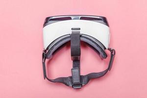 postura plana simples mínima com fone de ouvido de capacete de óculos de realidade virtual vr em fundo moderno na moda pastel rosa foto