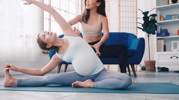 mulher grávida fazendo exercícios de pilates com personal trainer em casa. foto