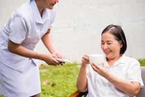 enfermeira asiática cuidando de paciente do sexo feminino no parque hospitalar foto