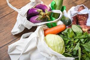 zero desperdício use menos conceito de plástico legumes frescos orgânicos em sacos de tecido de algodão ecológico na mesa de madeira foto