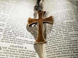 bíblia e cruz da religião sagrada foto