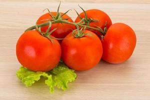 ramo de tomate em fundo de madeira foto