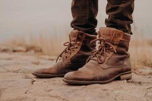 imagem das pernas do homem em botas velhas. conceito de venda de sapatos. Tempo de outono. vista horizontal. tiro ao ar livre. calçados foto