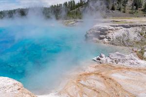 a piscina azul brilhante do excelsior geyser, na midway geyser, no parque nacional de yellowstone. foto